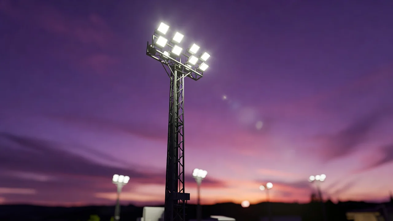 A floodlight pylon glowing against a purple dusk sky